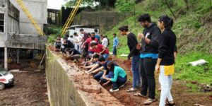Students planting the vernonia sapling along the compund wall of canteen extension dated 12th july 2019